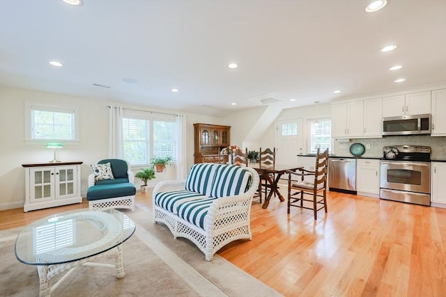 living area with plenty of natural light, light wood finished floors, and recessed lighting