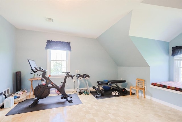 exercise room with plenty of natural light, baseboards, and vaulted ceiling