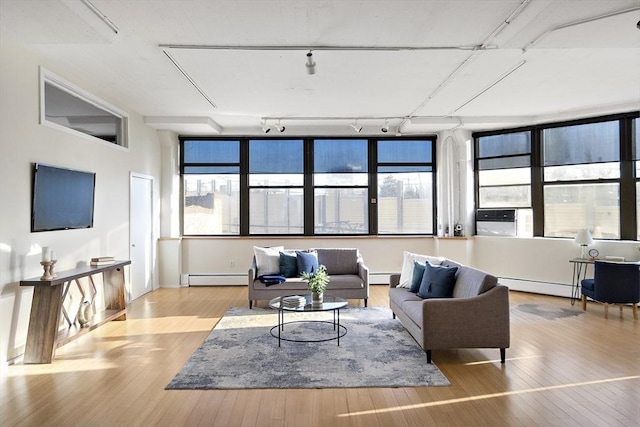 living room with a baseboard radiator, track lighting, and light hardwood / wood-style floors