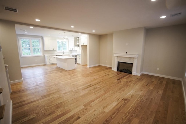 140 Tispaquin St, Middleboro, MA 02346 - unfurnished living room featuring light wood finished floors, a fireplace, recessed lighting, and baseboards