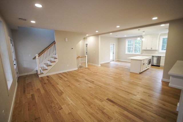 140 Tispaquin St, Middleboro, MA 02346 - unfurnished living room with light wood-style floors, recessed lighting, baseboards, and stairway