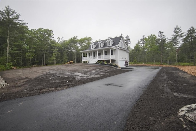140 Tispaquin St, Middleboro, MA 02346 - cape cod home featuring driveway, a porch, a view of trees, and an attached garage