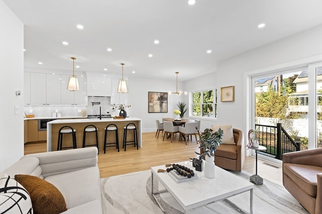 living room with an inviting chandelier and light hardwood / wood-style flooring