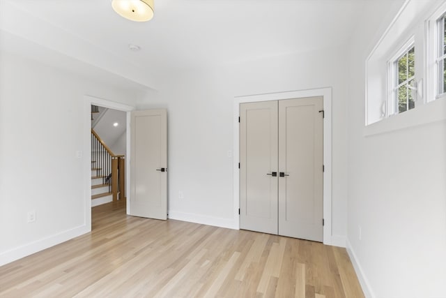 unfurnished bedroom with light hardwood / wood-style floors and a closet