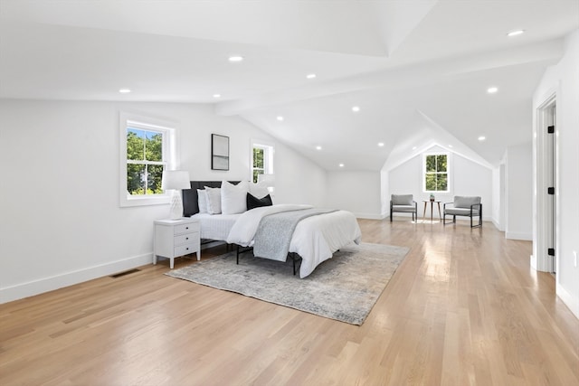 bedroom featuring light hardwood / wood-style floors, multiple windows, and vaulted ceiling