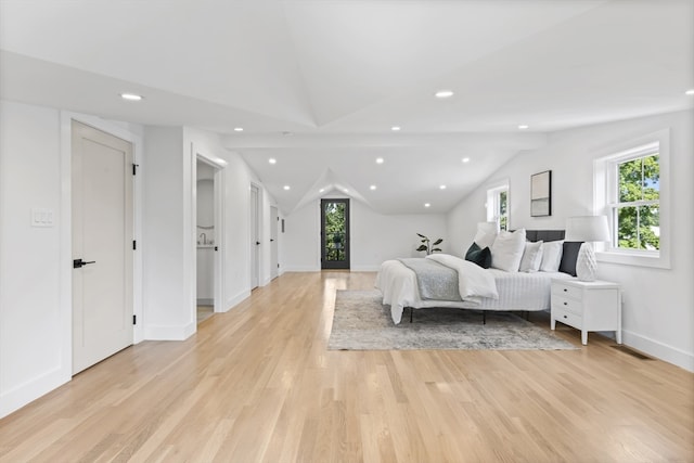 bedroom with light hardwood / wood-style floors and vaulted ceiling