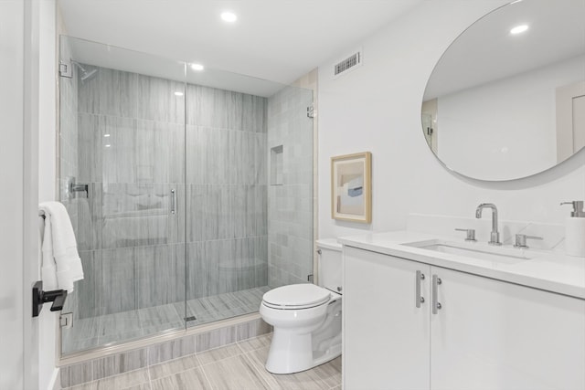 bathroom with vanity, toilet, and an enclosed shower