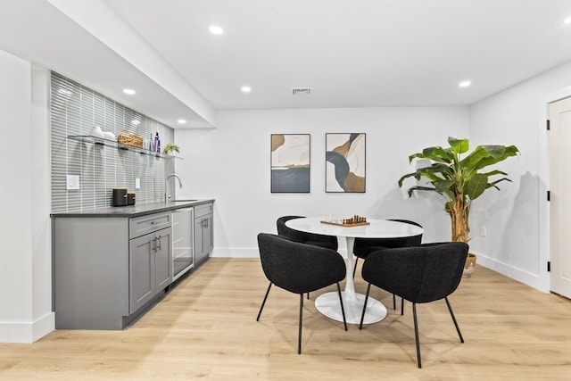 dining space featuring wet bar and light hardwood / wood-style floors