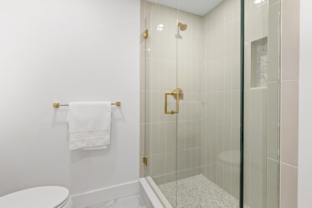 bathroom featuring toilet and a shower with shower door