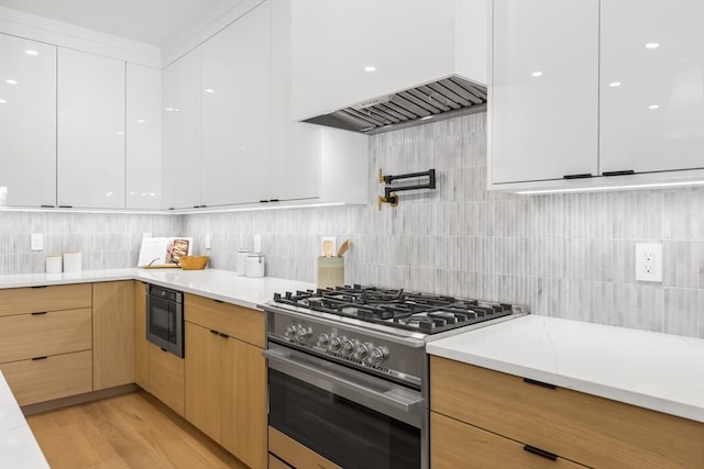 kitchen with white cabinetry, built in microwave, light brown cabinetry, high end stainless steel range oven, and light hardwood / wood-style flooring