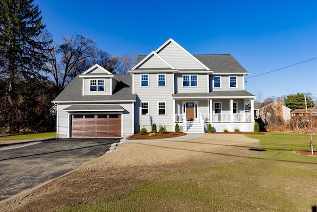 view of front of property with covered porch, a garage, and a front yard