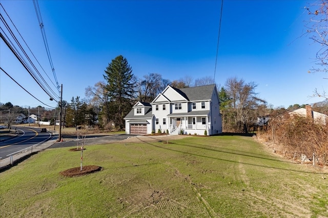 view of front of house featuring a front yard, a garage, and covered porch