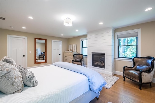 1 Putnam Rd, Bedford, MA 01730 - bedroom featuring wood finished floors, recessed lighting, and a large fireplace