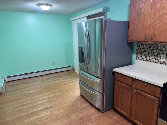 30 Wallace Cir Unit 30, Malden, MA 02148 - kitchen with stainless steel fridge with ice dispenser, backsplash, baseboard heating, light wood-style flooring, and light countertops