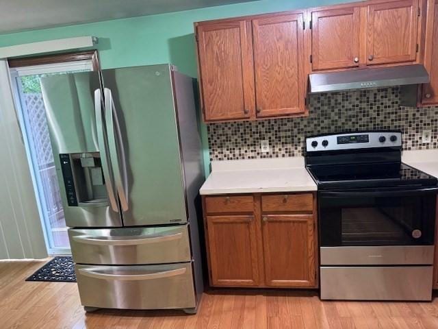 30 Wallace Cir Unit 30, Malden, MA 02148 - kitchen featuring appliances with stainless steel finishes, under cabinet range hood, light countertops, and light wood-style flooring