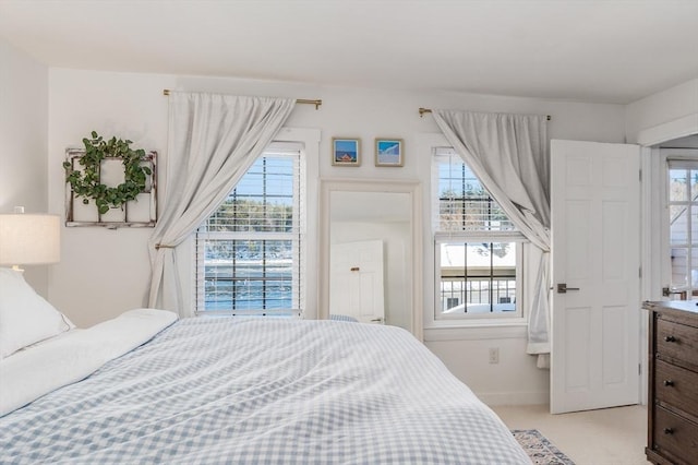 bedroom featuring baseboards and light carpet