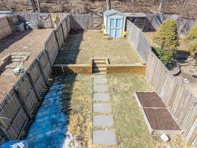 view of yard with a fenced backyard, a shed, an outdoor structure, and a garden