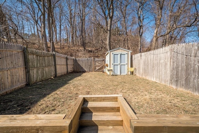 view of yard with an outbuilding, a fenced backyard, and a shed