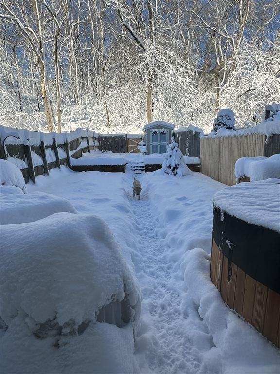 snowy yard featuring a fenced backyard