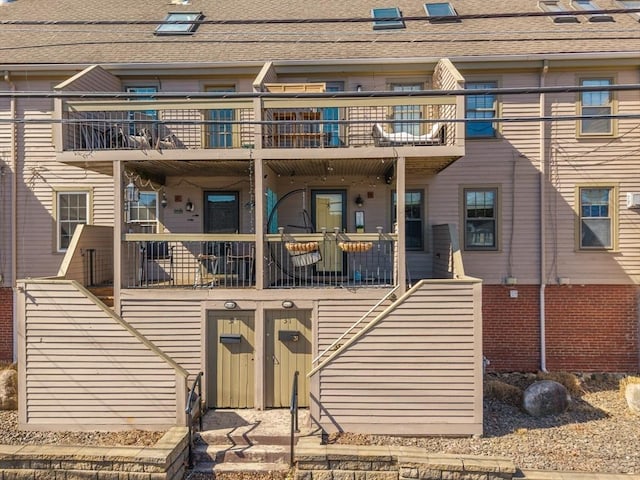 view of front of property featuring stairs and a balcony