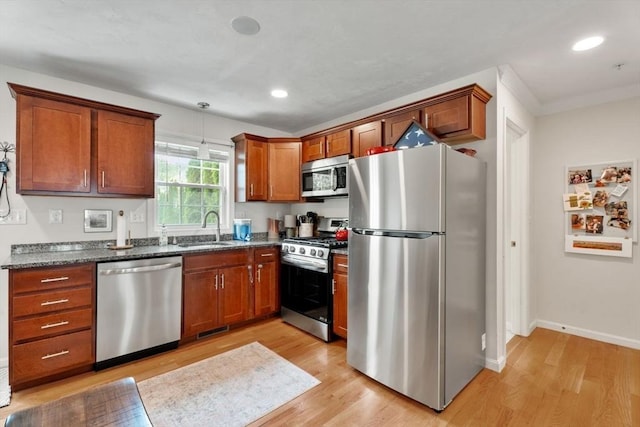 24 Merrimac Way Unit H, Tyngsborough, MA 01879 - kitchen featuring stainless steel appliances, a sink, light wood finished floors, dark stone counters, and brown cabinetry