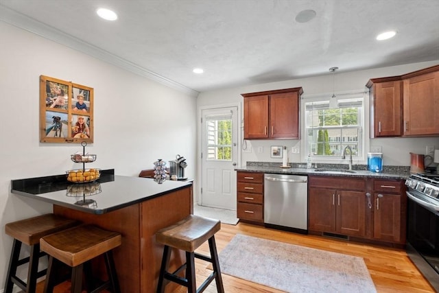 24 Merrimac Way Unit H, Tyngsborough, MA 01879 - kitchen with appliances with stainless steel finishes, a sink, a breakfast bar, dark countertops, and ornamental molding