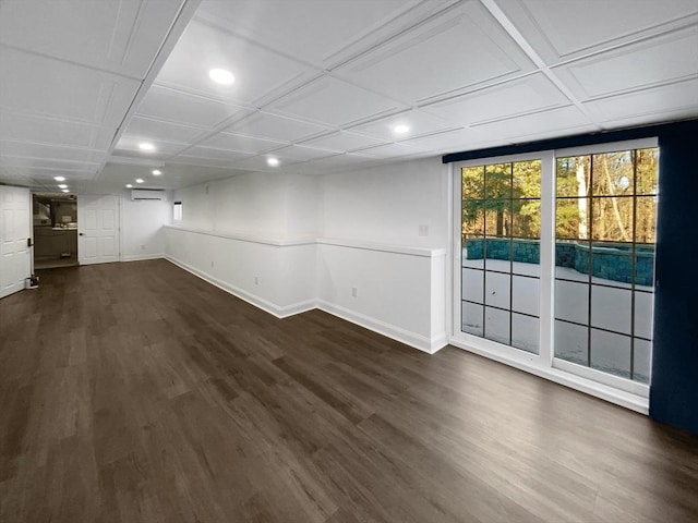 empty room featuring recessed lighting, dark wood-style flooring, a wall mounted air conditioner, and baseboards