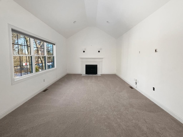 unfurnished living room featuring a fireplace with flush hearth, carpet, lofted ceiling, and baseboards