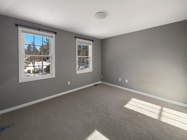 spare room with carpet and baseboards