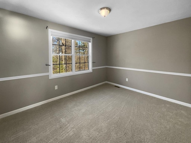 carpeted empty room featuring visible vents and baseboards