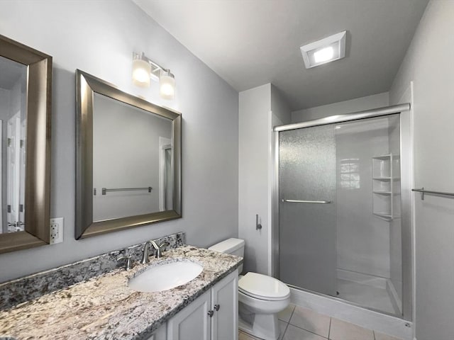 full bath with toilet, a stall shower, tile patterned flooring, and vanity