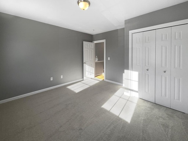 unfurnished bedroom featuring carpet, a closet, and baseboards