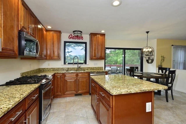 21 Hunt Dr, Stoughton, MA 02072 - kitchen with stainless steel appliances, light stone counters, a kitchen island, hanging light fixtures, and recessed lighting