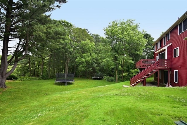 21 Hunt Dr, Stoughton, MA 02072 - view of grassy yard with a trampoline, stairway, and a deck