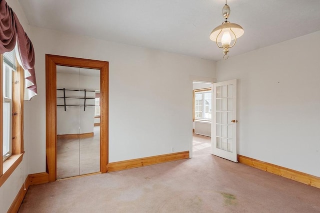 unfurnished room with carpet floors and baseboards