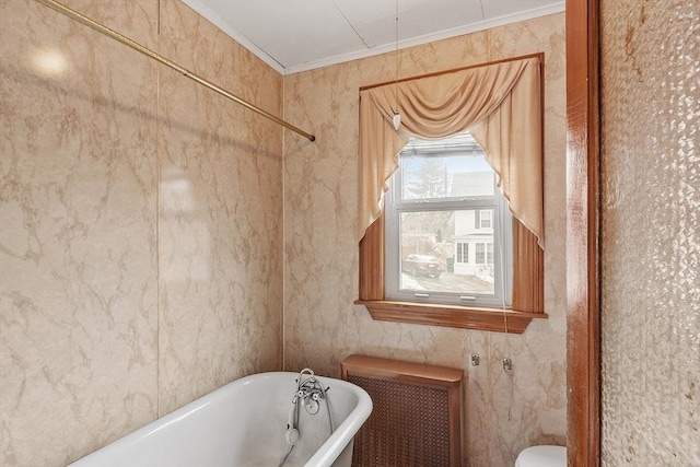 bathroom with crown molding, a freestanding bath, and radiator heating unit