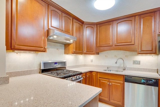 3 Concord Greene Unit 4, Concord, MA 01742 - kitchen with appliances with stainless steel finishes, under cabinet range hood, a sink, light stone countertops, and brown cabinets