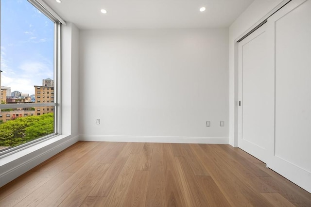 700 Harrison Ave Unit Ph-610, Boston, MA 02118 - unfurnished bedroom with light wood finished floors, baseboards, recessed lighting, a city view, and a closet