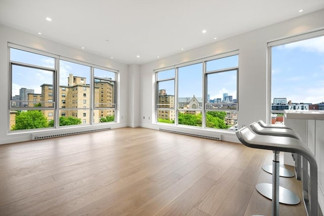 700 Harrison Ave Unit Ph-610, Boston, MA 02118 - unfurnished living room with a view of city, baseboard heating, wood finished floors, and recessed lighting