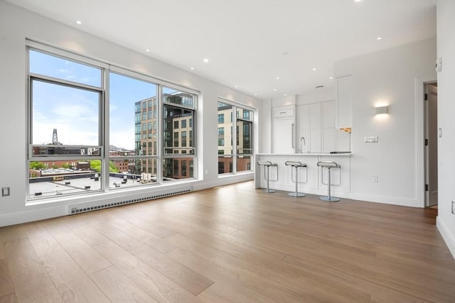 700 Harrison Ave Unit Ph-610, Boston, MA 02118 - unfurnished living room featuring light wood-style floors, baseboards, a city view, a sink, and recessed lighting