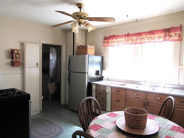 31 Graham St, Quincy, MA 02169 - kitchen featuring freestanding refrigerator, black range with gas stovetop, a sink, ceiling fan, and light countertops