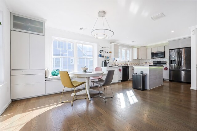 dining space featuring crown molding and dark wood-type flooring