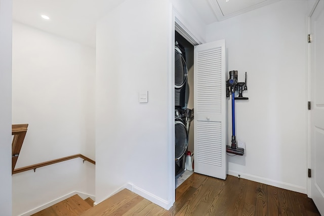 clothes washing area with stacked washer / drying machine and dark hardwood / wood-style floors