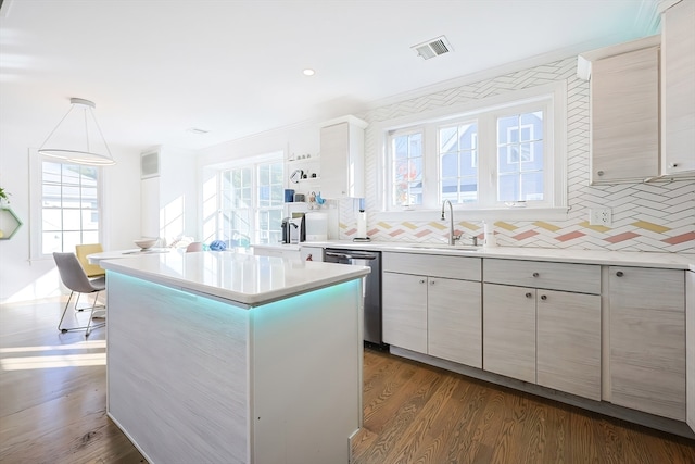 kitchen with dark wood-type flooring, a center island, decorative light fixtures, and a wealth of natural light