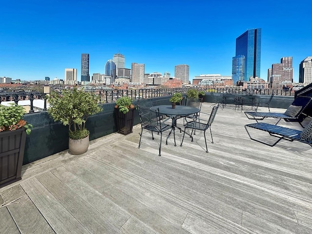 deck with a skyline view and outdoor dining space