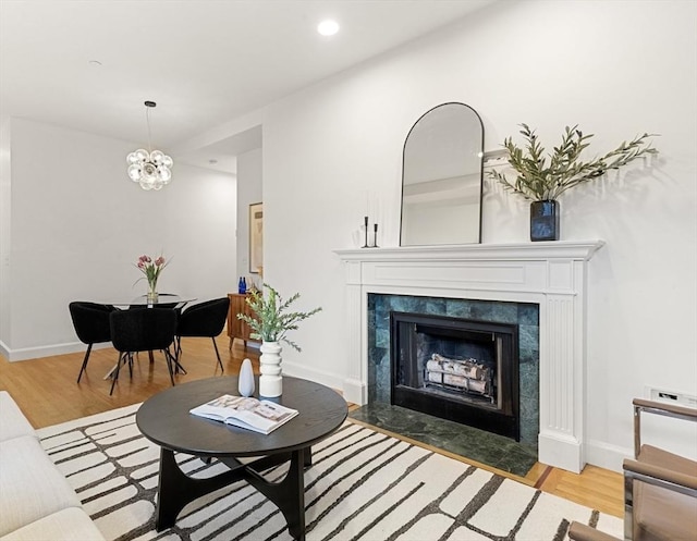living area with wood finished floors, baseboards, a fireplace, and recessed lighting