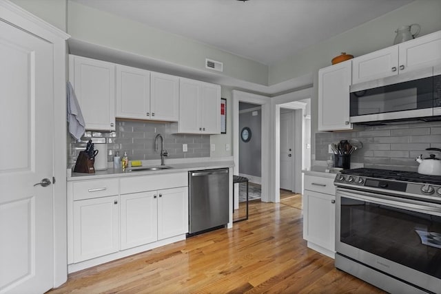 40 King St Unit 3, Boston, MA 02122 - kitchen featuring appliances with stainless steel finishes, tasteful backsplash, light countertops, and white cabinets
