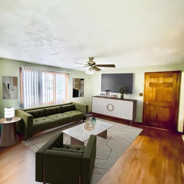 living room with light hardwood / wood-style flooring and ceiling fan