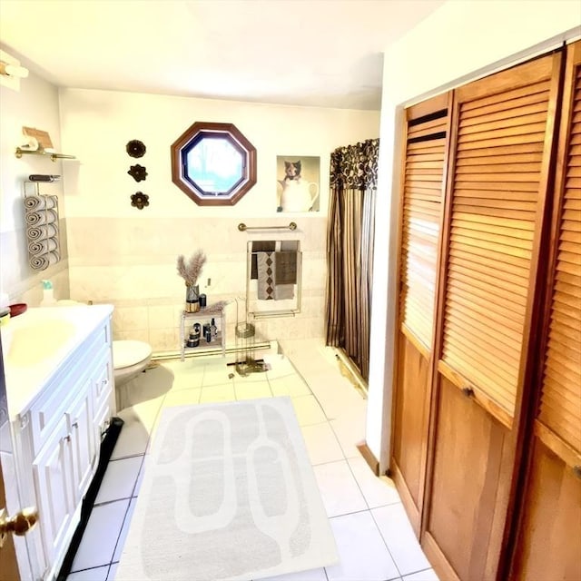 bathroom featuring tile walls, vanity, tile patterned floors, and toilet