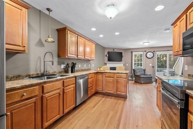 kitchen featuring sink, decorative light fixtures, electric range oven, stainless steel dishwasher, and kitchen peninsula